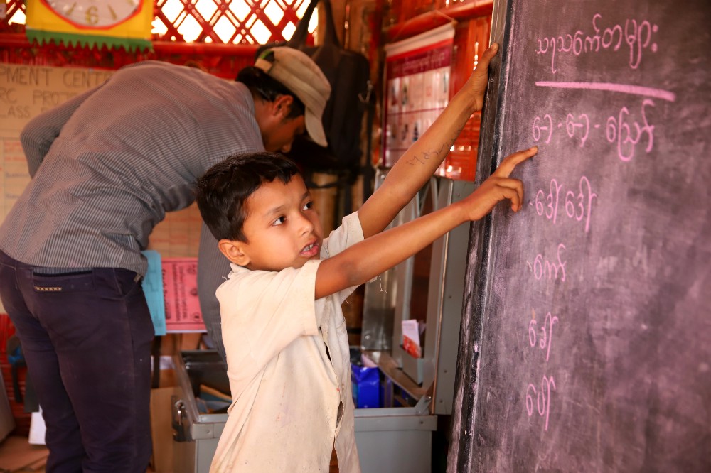 Shukhon wants to be a teacher when he grows up and often volunteers to lead his class in reading and writing. Photo: WFP/Gemma Snowdon.