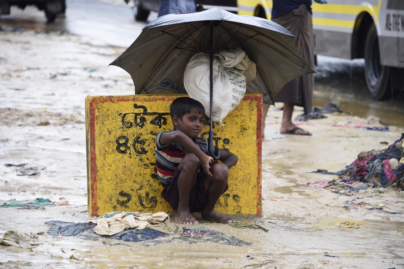 A young Rohingya refugee shelters from the rain with an umbrella while sitting at Kutupalong refugee camp in the Bangladeshi locality of Ukhia on September 19, 2017. (AFP/Dominique Faget)