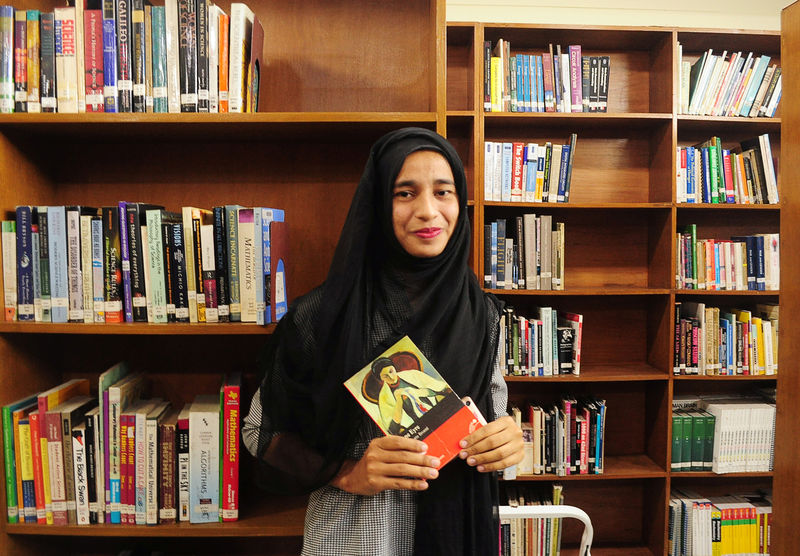 © Reuters. Formin Akter, a Rohingya refugee girl, holds a copy of the novel Jane Eyre, which she says is her new favourite book, inside the library of the Asian University for Women in Chittagong