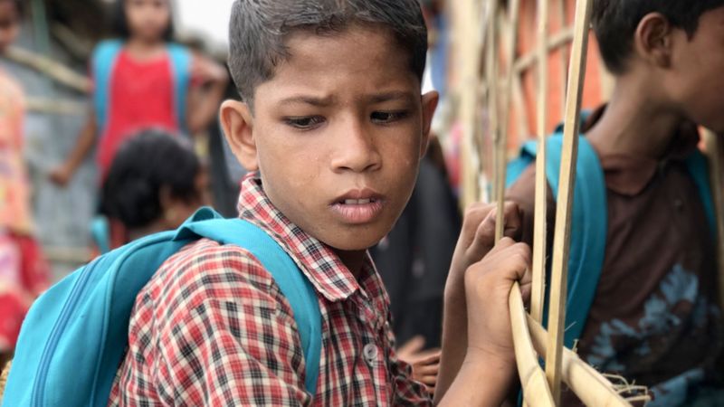 A Rohingya Muslim boy waits outside a makeshift learning center to attend informal classes at a refugee camp in Bangladesh in May 2018. (Shashank Bengali / Los Angeles Times)