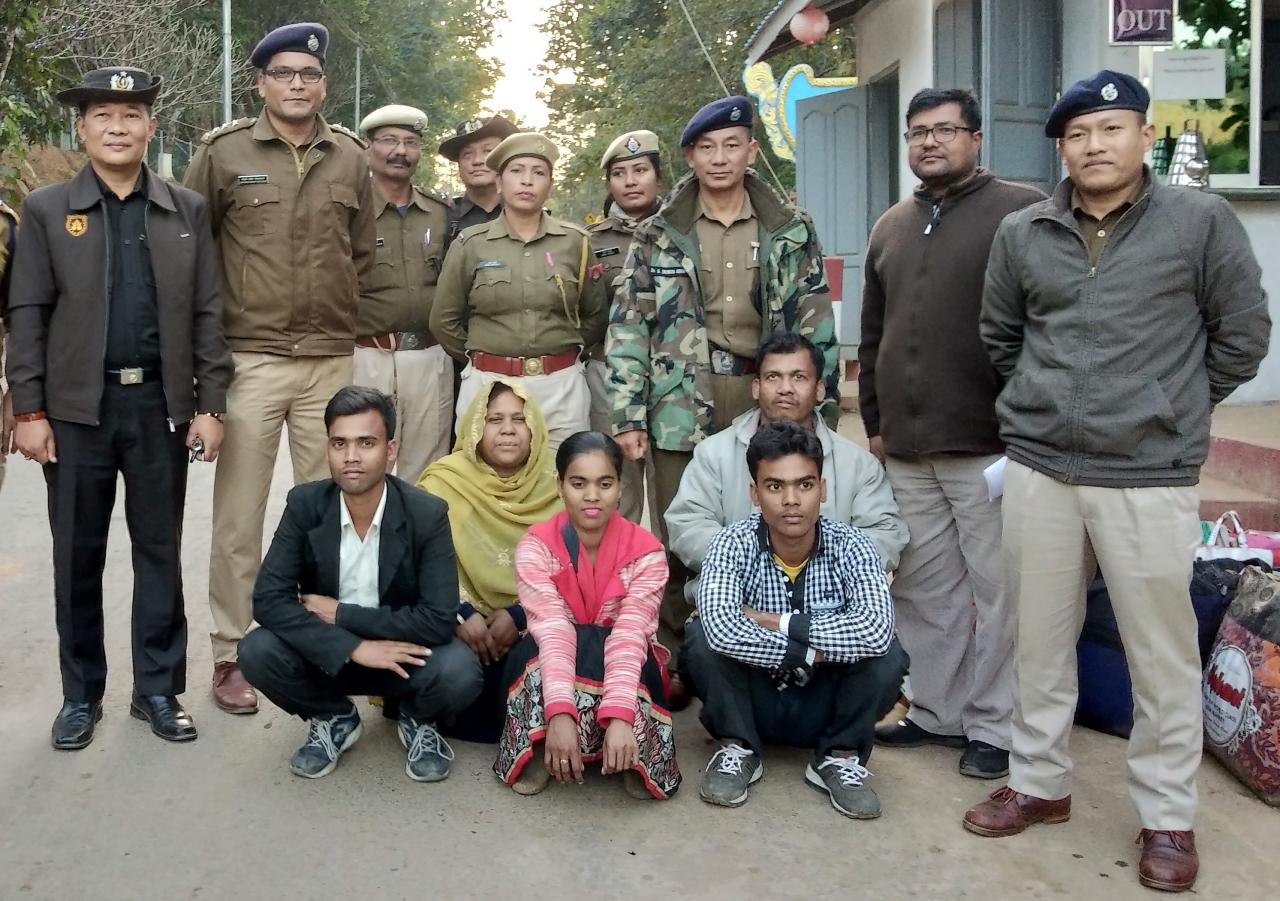 Members of a Muslim Rohingya family sit as they pose for a photograph with Indian and Myanmar security officials before their deportation on India-Myanmar border at Moreh in the northeastern state of Manipur, India, January 3, 2019. REUTERS/Stringer