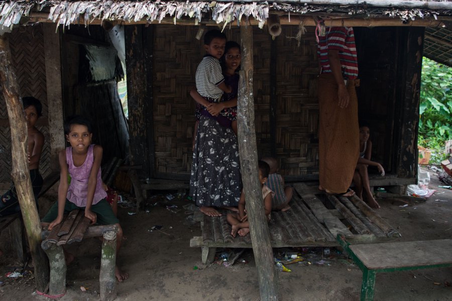 A Rohingya Muslim family stand in front of their house at Pan Taw Pyin village in Maungdaw in Myanmar's northern Rakhine state. AFP