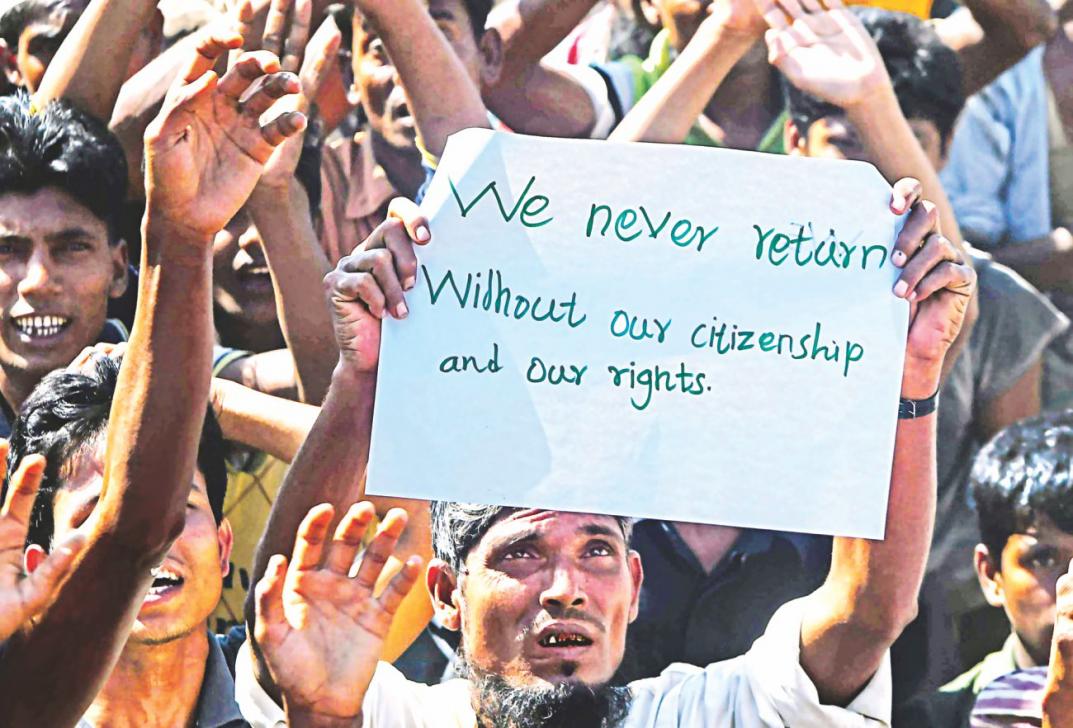 A Rohingya man carries a placard during a protest at the Unchiprang refugee camp in Teknaf. Photo: AFP