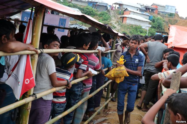 A Rohingya refugee boy walks out after collecting meat from a relief distribution center in the Balukhali refugee camp in Cox's Bazar, Bangladesh, Aug. 23, 2018.